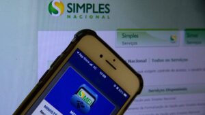 Iamgem de app do Simples e tela de computador no portal do Simples. Prazo do Simples para regularizar vai até sexta-feira (31)