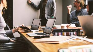 Imagem com pessoas à mesa e notebooks sobre a mesa. Projeto geração tech abre vagas no Ceará