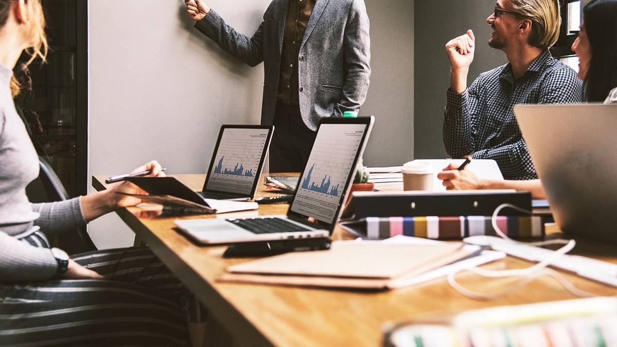 Imagem com pessoas à mesa e notebooks sobre a mesa. Projeto geração tech abre vagas no Ceará