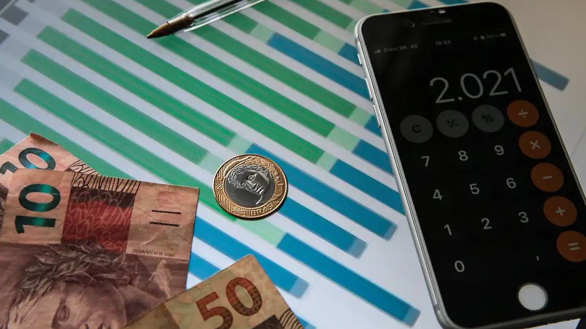 Calculadora e notas de R$50 e 10 sobre a mesa, além de uma moeda de 1 real. Resultado primário de 2024 foi o segundo melhor da década, diz Tesouro nacional