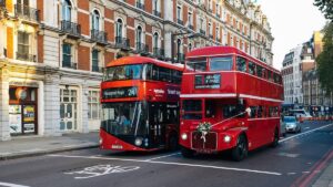 Imagem de dois ônibus vermelhos na cidade de Londres. Taxa de viagem do Reino Unido passa a ser cobrada de brasileiros