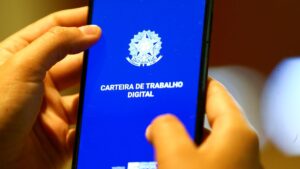 Pessoa segurando um celular, com a carteira de trabalho digital, representando a criação de novos empregos.