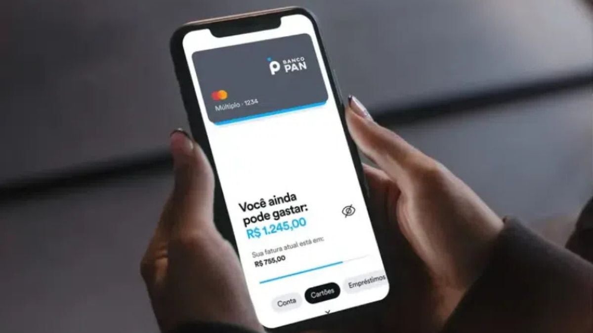 Pessoa segurando um smartphone exibindo o aplicativo do Banco Pan no 4T24, mostrando saldo disponível no cartão de crédito.