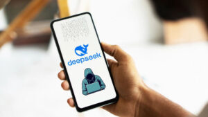 Celular exibe logotipo do DeepSeek com ícone de hacker, destacando vulnerabilidades do sistema.