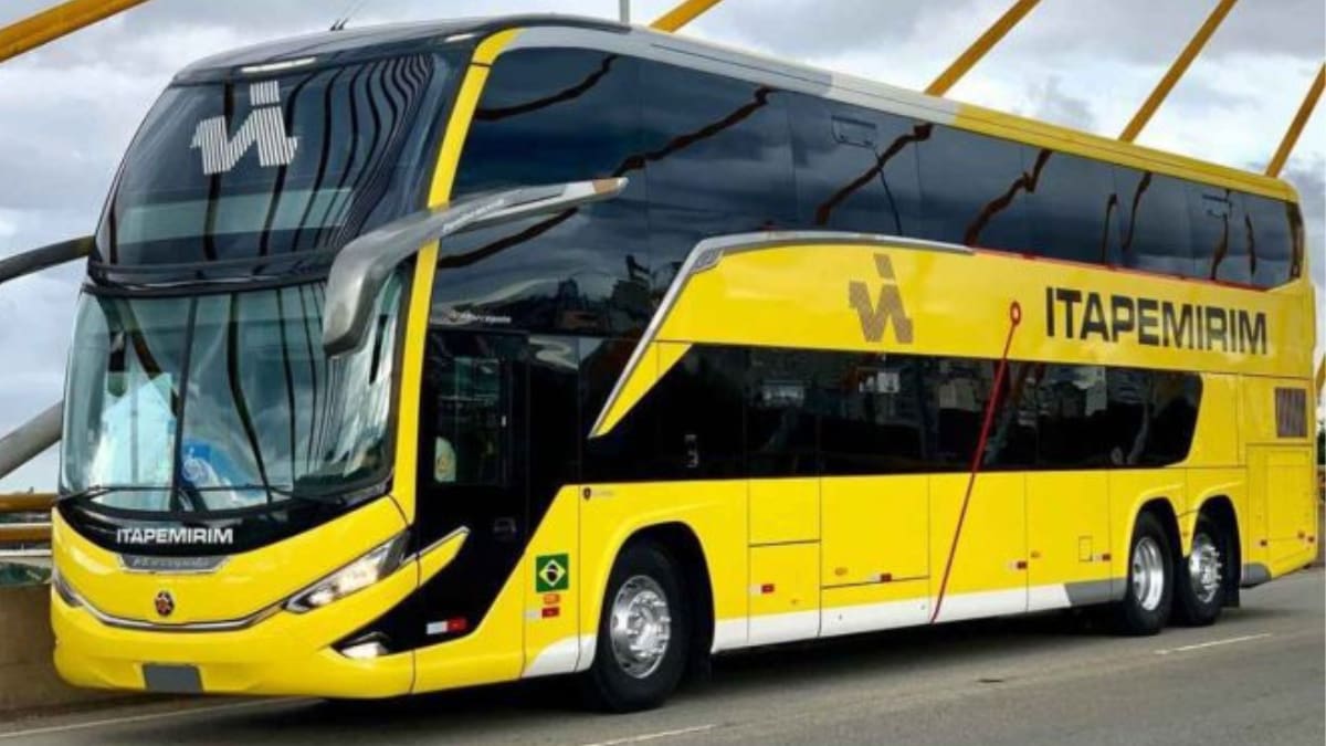 Ônibus de dois andares do Grupo Itapemirim, pintado de amarelo e preto, circulando sobre uma ponte. Veículo moderno com a marca da empresa.