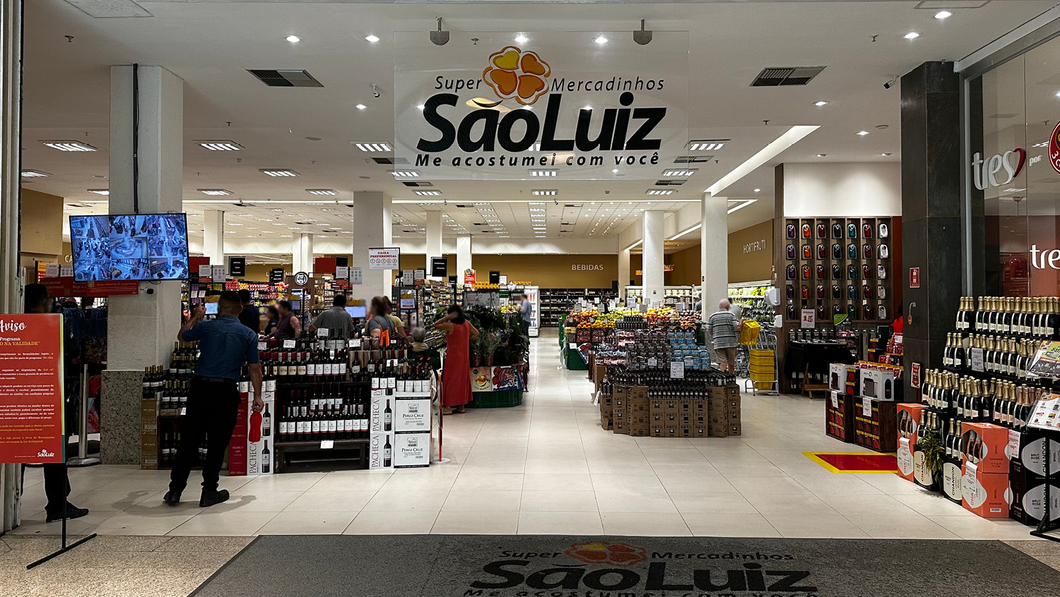 A imagem mostra uma das unidades do Mercadinhos São Luiz, do Grupo São Luiz. Ao fundo mostra prateleiras de produtos.