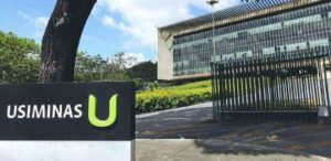 A imagem mostra a fachada de uma unidade da Usiminas.