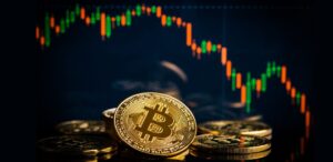 A imagem mostra criptomoedas de Bitcoin e ao fundo um gráfico caindo, representando a queda do Bitcoin.