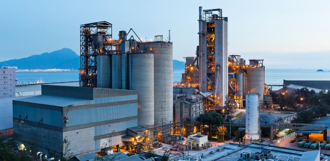 A imagem mostra uma foto aérea de uma indústria, representando a importância da reindustrialização brasileira.