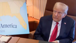Donald Trump em reunião segurando um mapa enquanto discute tarifas sobre aço e alumínio, política que afeta exportadores globais.