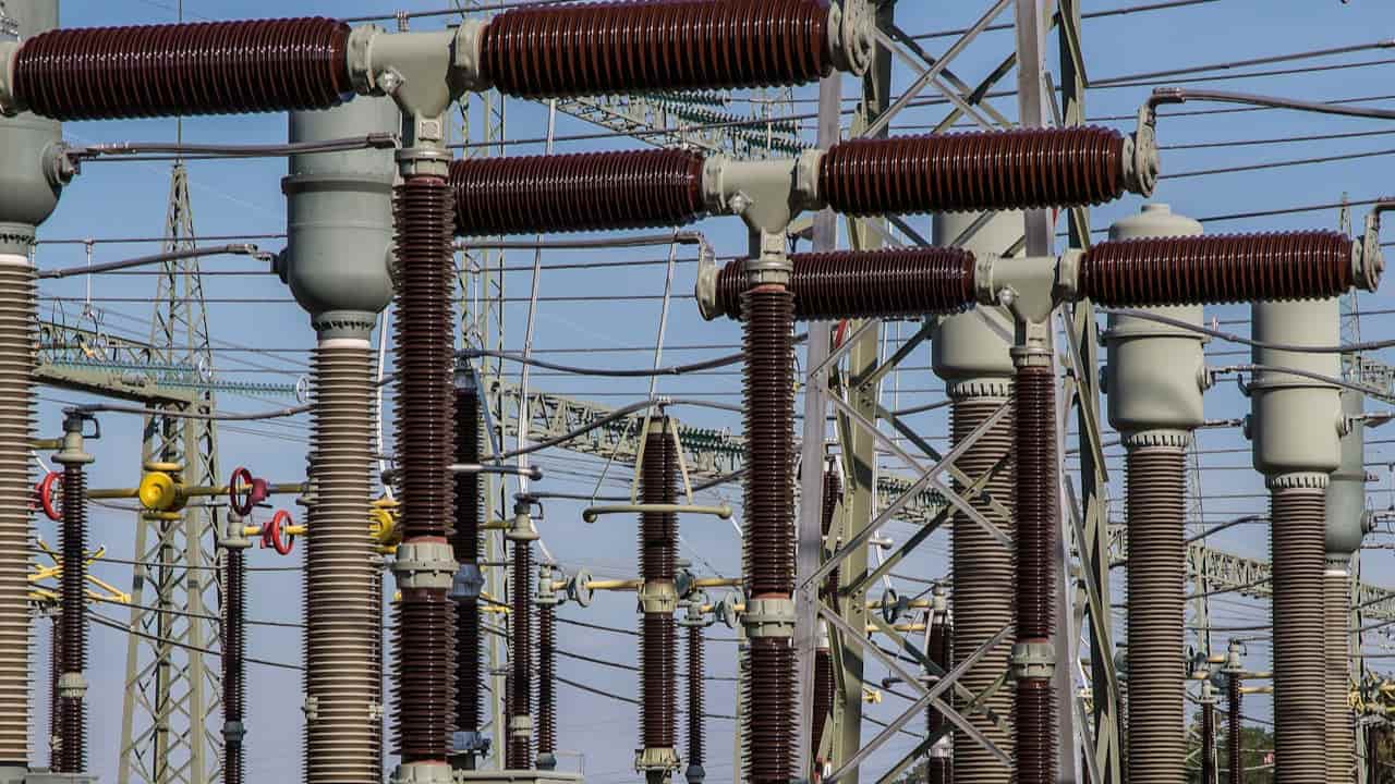 Infraestrutura de distribuição de energia elétrica do Grupo Energisa, com isoladores e equipamentos de alta tensão em subestação.