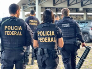 Agentes da Polícia Federal e da Força-Tarefa durante operação investigando lavagem de dinheiro em fintechs, caminhando em um estacionamento