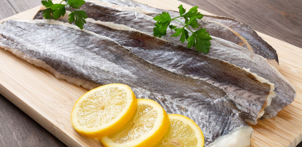 A imagem mostra uma tábua de cortes com filés de peixe em cima e rodelas de limão para decorar. Essa imagem simboliza o aumento dos preços na Quaresma.