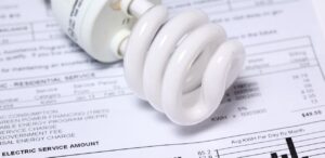 A imagem mostra uma conta de luz e uma lâmpada para representar a conta de luz sem taxa.
