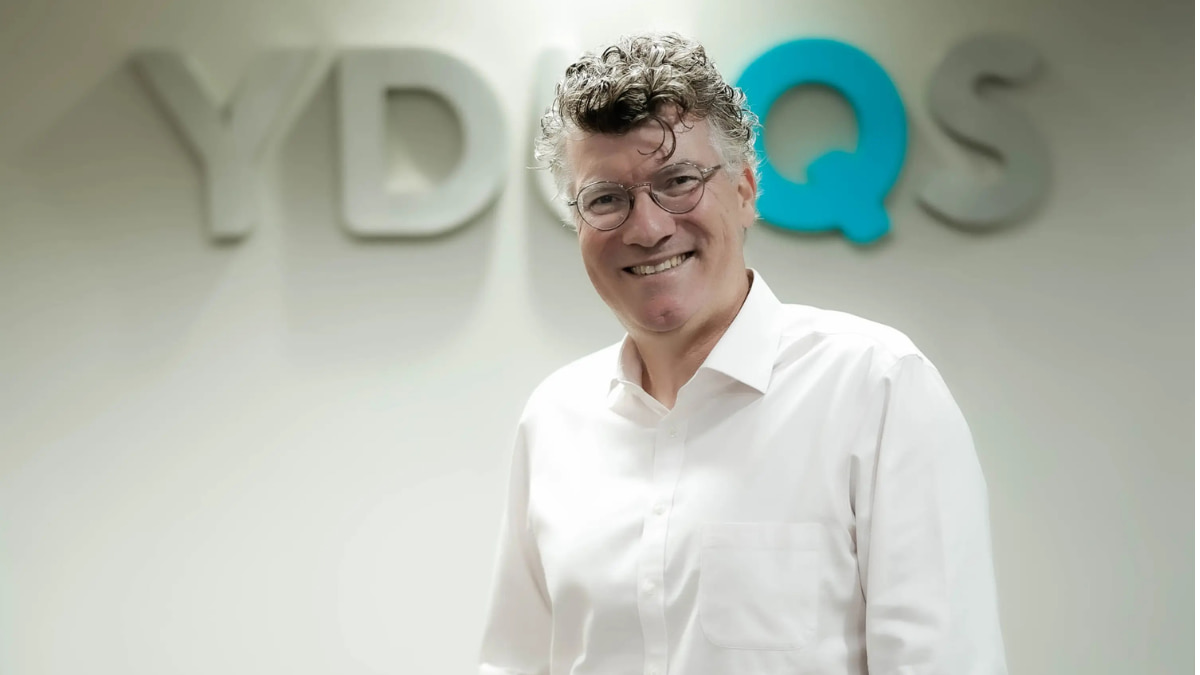Eduardo Parente, CEO da Yduqs, sorrindo em frente ao logotipo da empresa, representando a recuperação financeira com lucro no 4T24.