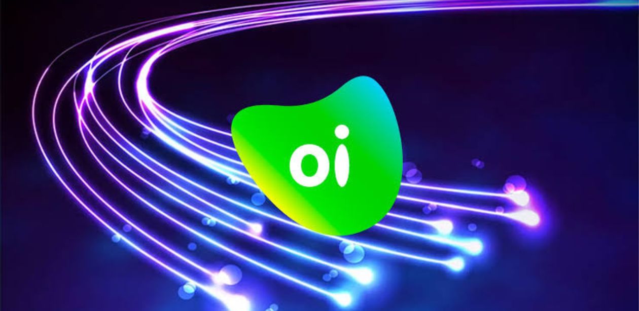 A imagem mostra a logo da Oi e ícones tecnológicos ao fundo representando a venda de ativos da Oi (OIBR3).