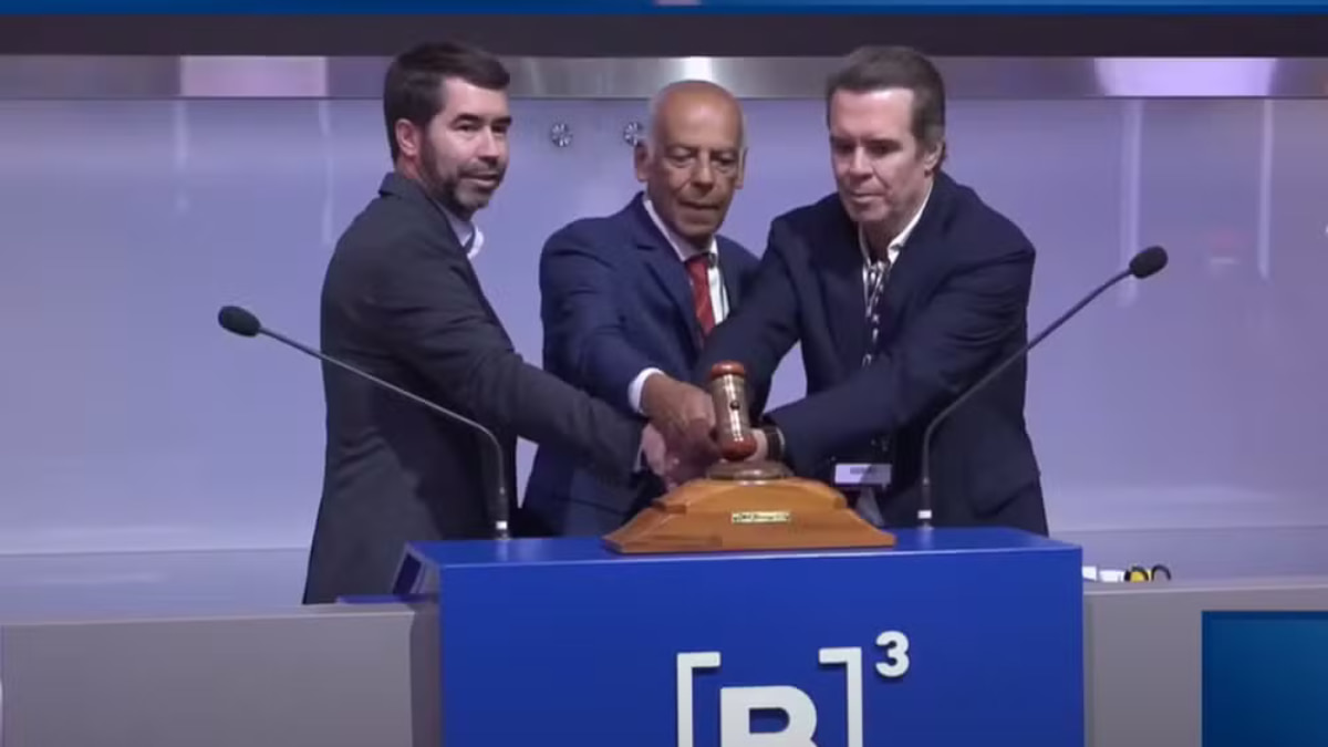 Representantes do Grupo Comporte durante o leilão da CPTM na B3, segurando o martelo do pregão em São Paulo.