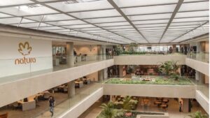 Interior da sede da Natura &Co com espaços abertos e vegetação, refletindo a estratégia de sustentabilidade e inovação da companhia.