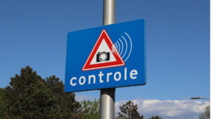 Placa de aviso sobre radares instalados em São Paulo, indicando controle de velocidade com símbolo de câmera e ondas de sinal.