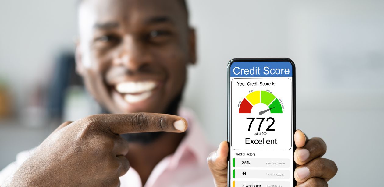 A imagem mostra um homem desfocado segurando um celular e na tela aparece um gráfico de score de crédito.