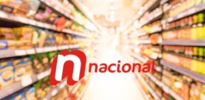 A imagem mostra o corredor de um supermercado e a logo dos Supermercados Nacional no centro.