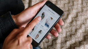 Pessoa navegando no TikTok Shop Brasil em um smartphone, visualizando roupas e preços na plataforma de e-commerce do TikTok.