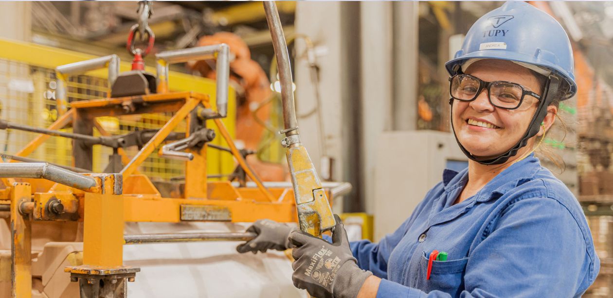 A imagem mostra uma mulher na parte interna de uma das empresas Tupy para representar que a Tupy reverte lucro.