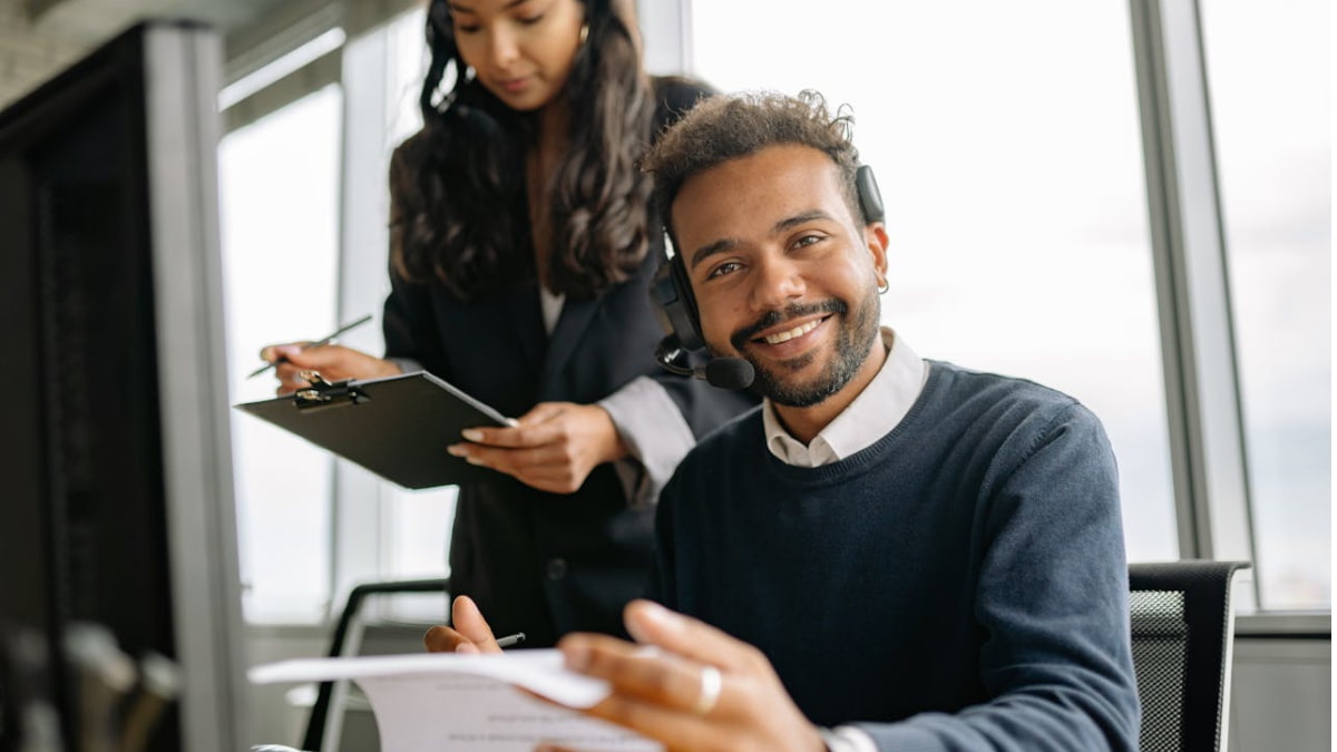 Atendente sorridente com headset simboliza a experiência do consumidor com atendimento direto e personalizado.