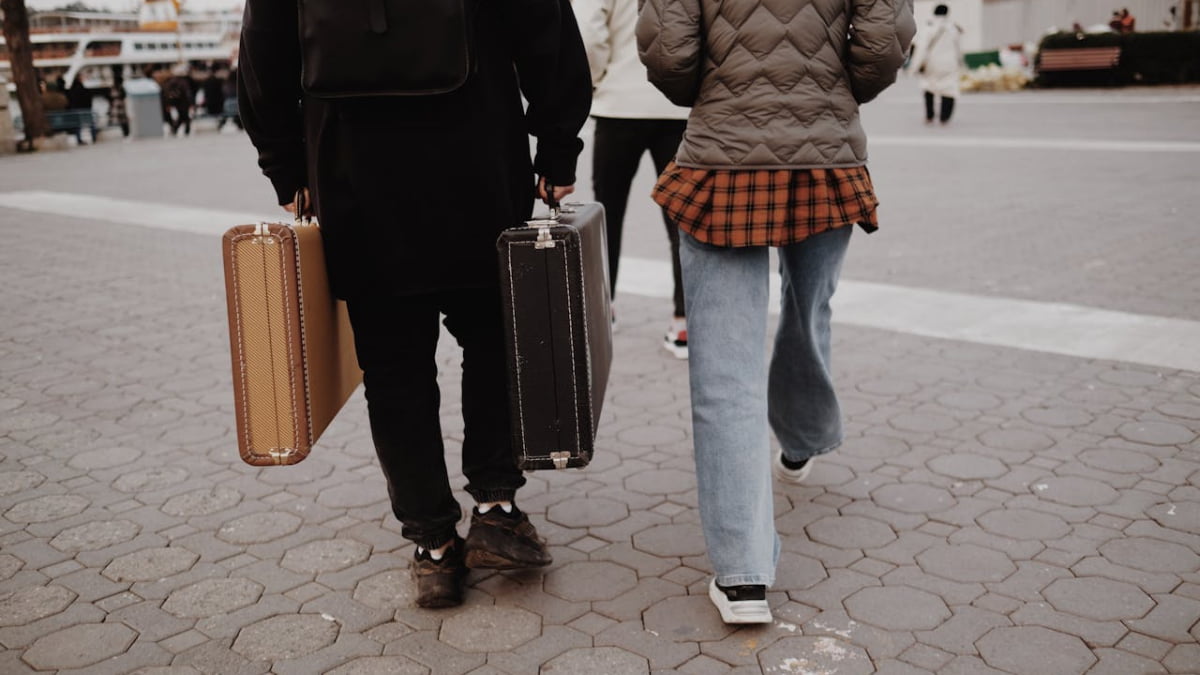 Pessoas com malas caminhando em direção ao embarque, ilustrando a responsabilidade da agência de turismo na orientação ao cliente.