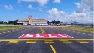 Aeroporto de Guarujá com pista reformada e torre de controle ao fundo, após investimentos do Novo PAC em infraestrutura aeroportuária.