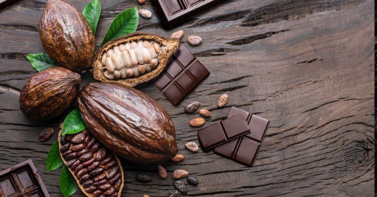 A imagem mostra chocolates e cacau para representar que a demanda por cacau subiu.