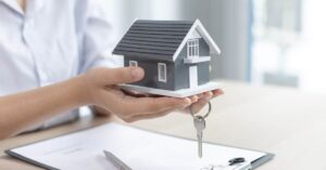 A imagem mostra a miniatura de uma casa para representar o crédito imobiliário