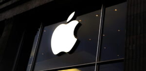 Logo da Apple iluminado na fachada de uma loja.