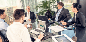 A imagem mostra várias pessoas sentadas à mesa em uma reunião para representar as empresas brasileiras.