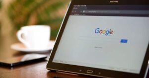 A imagem mostra um notebook na página de busca do google para representar que o Google enfrenta julgamento.