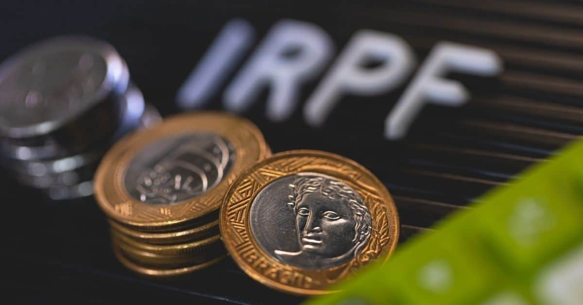 A imagem mostra moedas e ao fundo escrito IRPF para representar o Imposto de Renda 2025