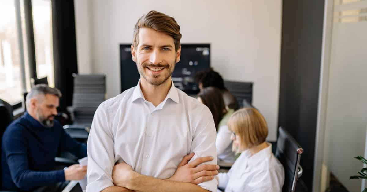 Líder sorridente à frente da equipe simboliza a liderança humanizada nas empresas