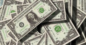 A imagem mostra notas de dólares para representar o mercado financeiro