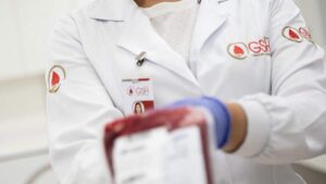Profissional da saúde do Grupo GSH segura bolsa de sangue; Rede D’or vende participação na GSH por R$ 1,58 bilhão.