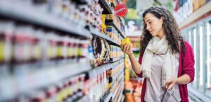 A imagem mostra uma pessoa fazendo compras em um supermercado para representar as vendas no varejo