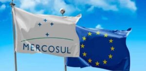 Bandeiras do Mercosul e da União Europeia tremulando, simbolizando o acordo comercial entre os blocos