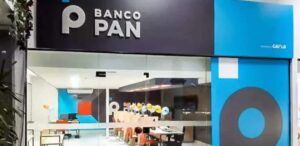 Fachada de uma agência do Banco PAN, com logotipo visível e interior moderno — Procon multa Banco Pan