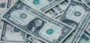 Cédulas de dólar americano sobrepostas, representando a alta da cotação do dólar hoje.