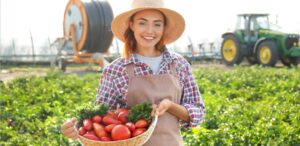 A imagem mostra uma produtora rural no meio do campo para representar a queda de preços ao produtor.