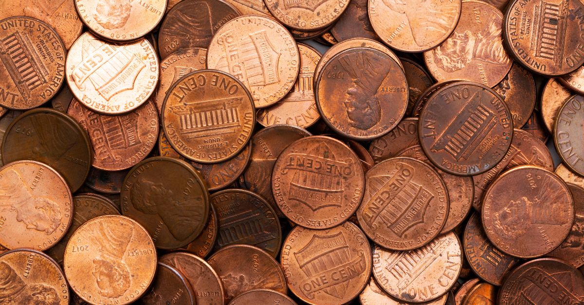 A imagem mostra várias moeda de 1 centavo de dólar