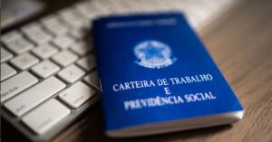 A imagem mostra uma carteira de trabalho para representar que o emprego estável e renda em alta afetam economia