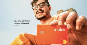 A imagem mostra um homem segurando um cartão do Banco Inter para representar o Inter Prime