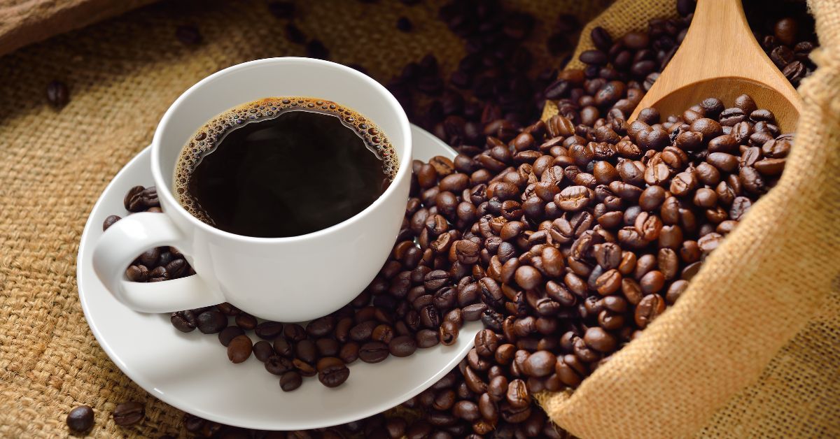 A imagem mostra uma xícara de café com grãos para representar o café impróprio para consumo
