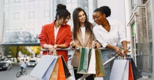A imagem mostra mulheres com sacolas de compras para representar o Dia Livre de Impostos
