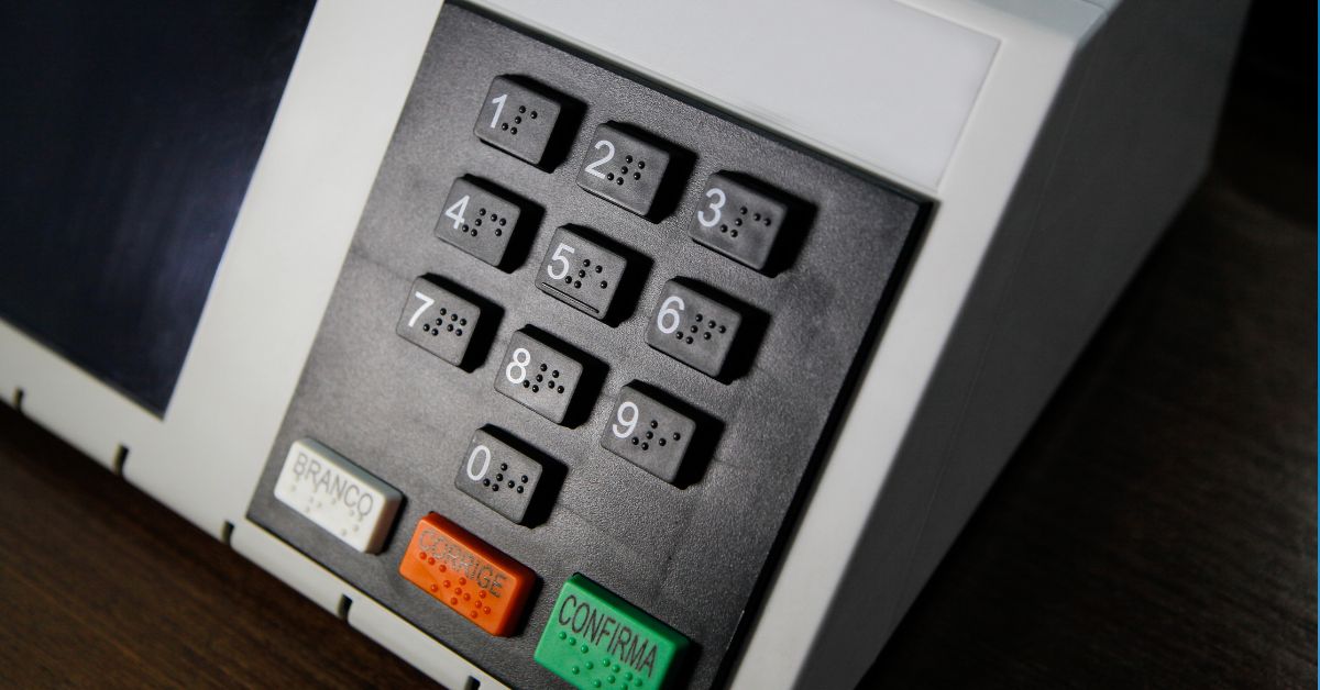A imagem mostra uma urna eletrônica para representar o fim da reeleição